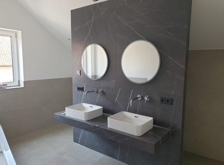 Modernes Badezimmer mit Doppelwaschbecken und großformatigen Fliesen